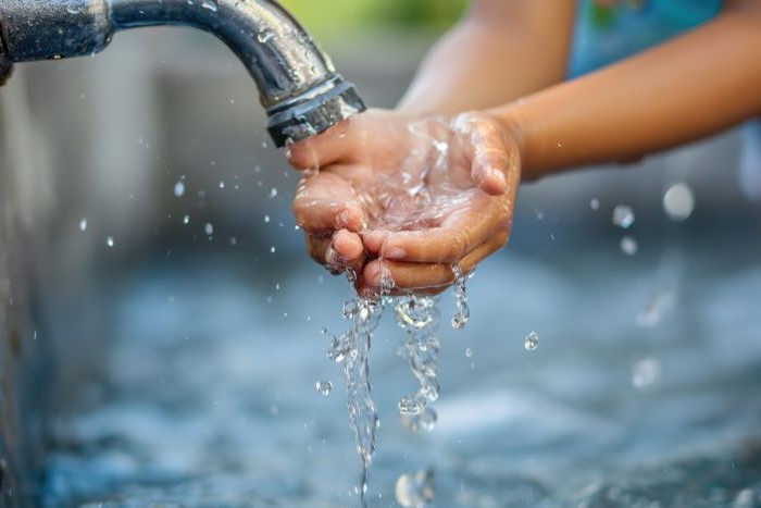 蛇口から水を掬う手