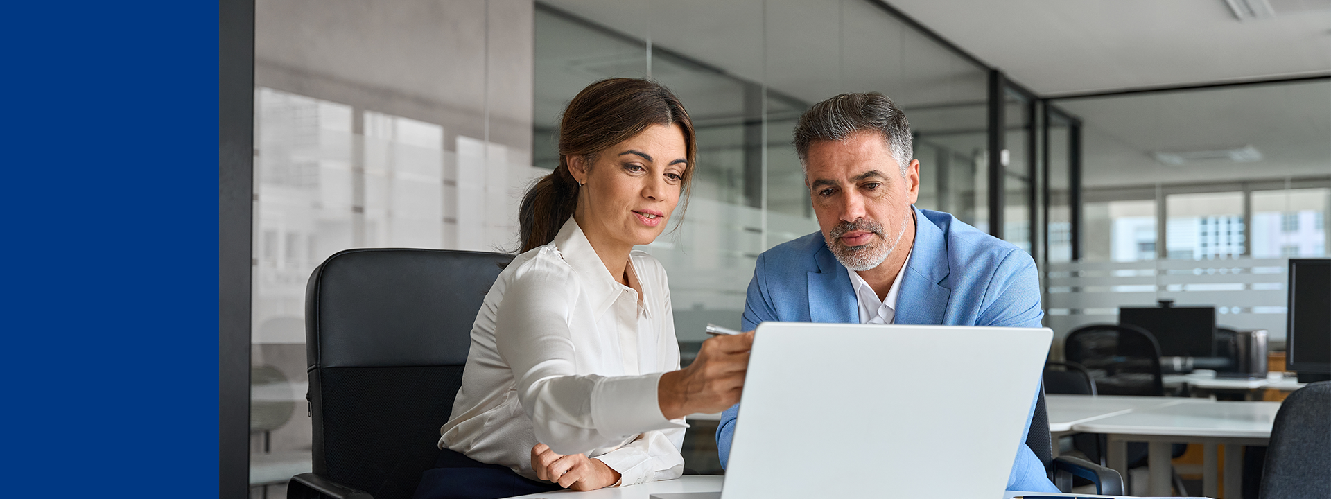 Two professionals collaborating at a desk with a laptop in a modern office, representing MDS Consulting’s smart and secure validation processes for regulated medical devices.