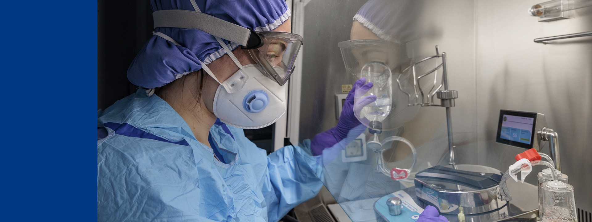 Microbiology technician performing sterility testing inside a controlled aseptic environment, using sterile tools and culture media.