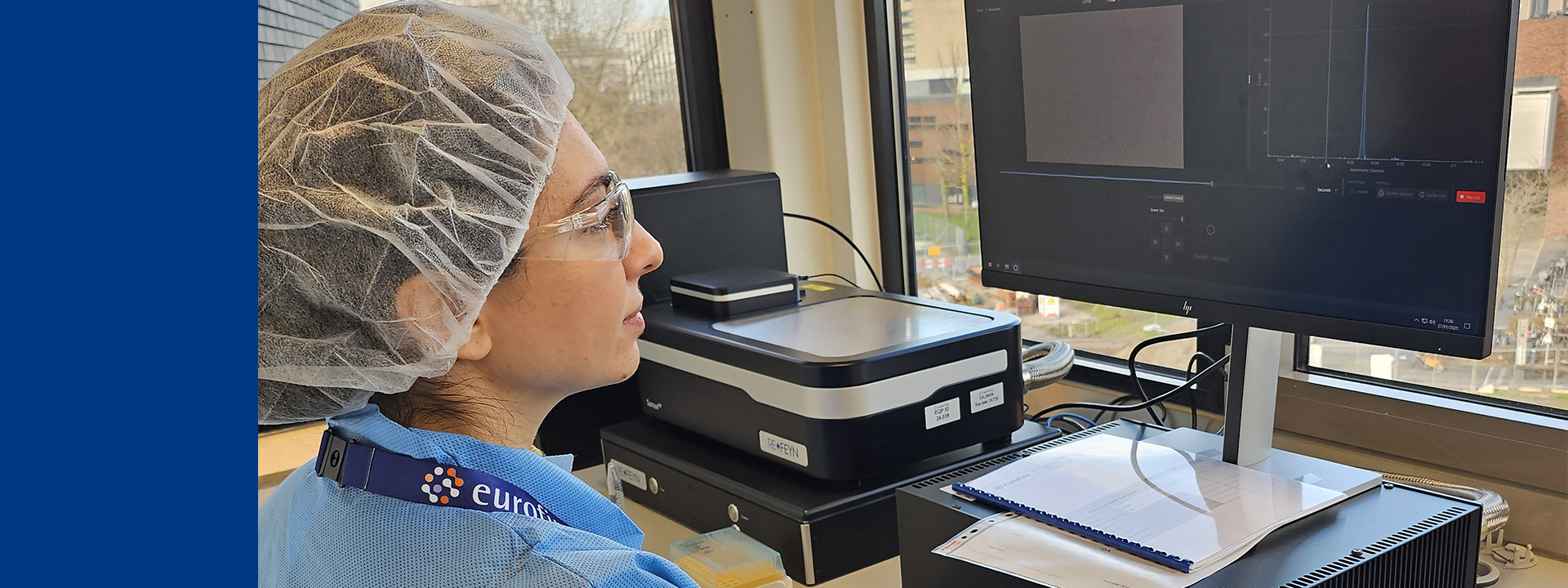 Laboratory technician reviewing empty and full viral capsid analysis data on advanced analytical equipment at a computer workstation.