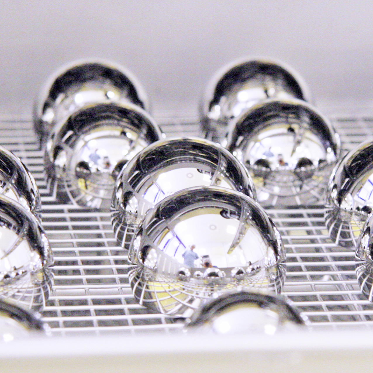 Hochglanzpolierte, kugelförmige Medizinprodukte auf einer Gitteroberfläche.