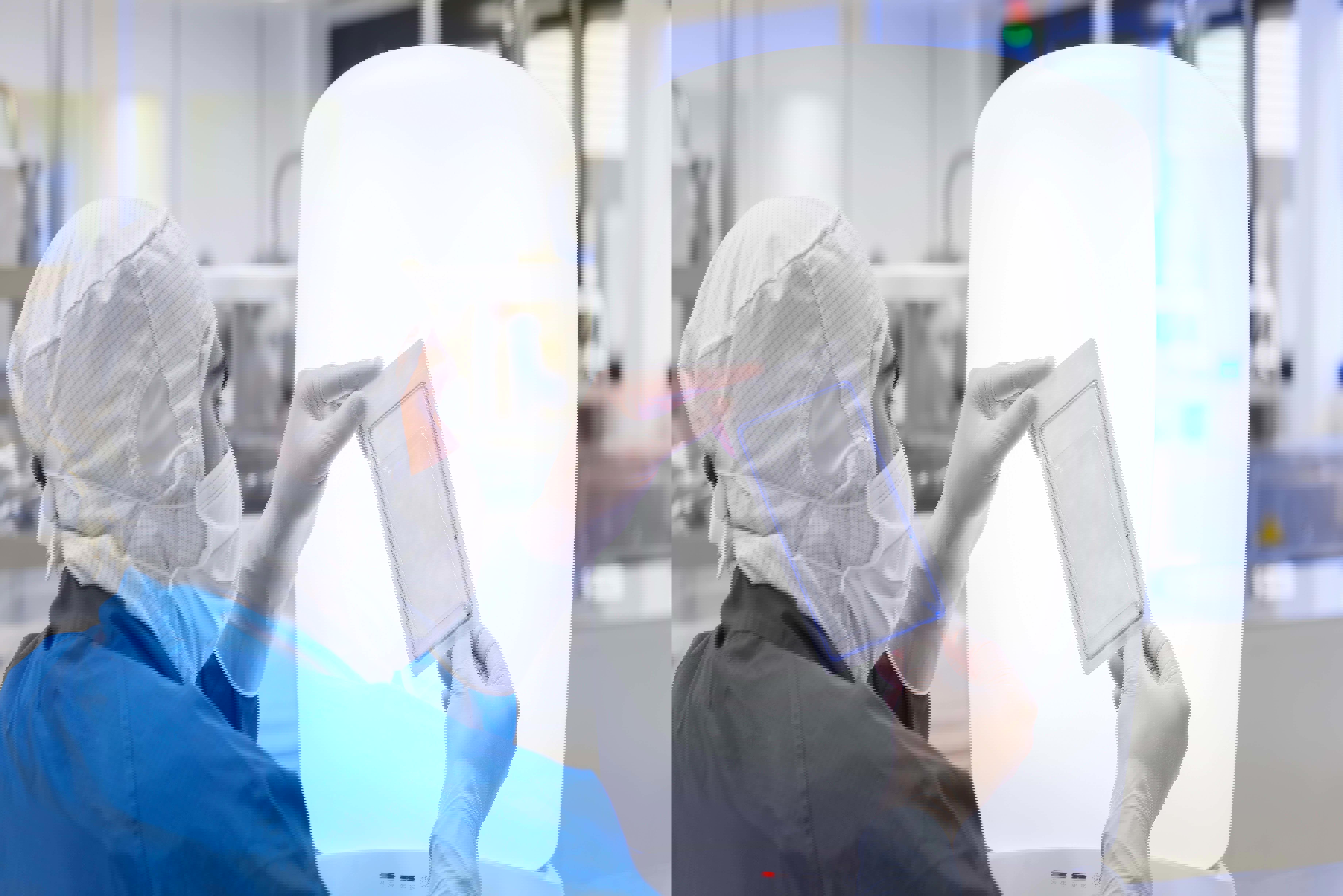 Eine Fachkraft in Reinraumbekleidung mit Haube, Mundschutz und Handschuhen inspiziert eine versiegelte Verpackung vor einem Lichtkasten – Qualitätskontrolle in einem Reinraumlabor der Medizintechnik.