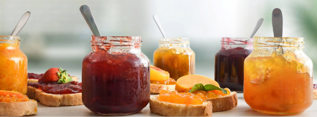 jars-full-of-jam-of-various-flavors-and-slices-of-bread-with-jam-decorated-and-kitchen-background_11034-x1