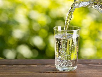water-from-jug-pouring-into-glass-on-table-outdoors_352x264