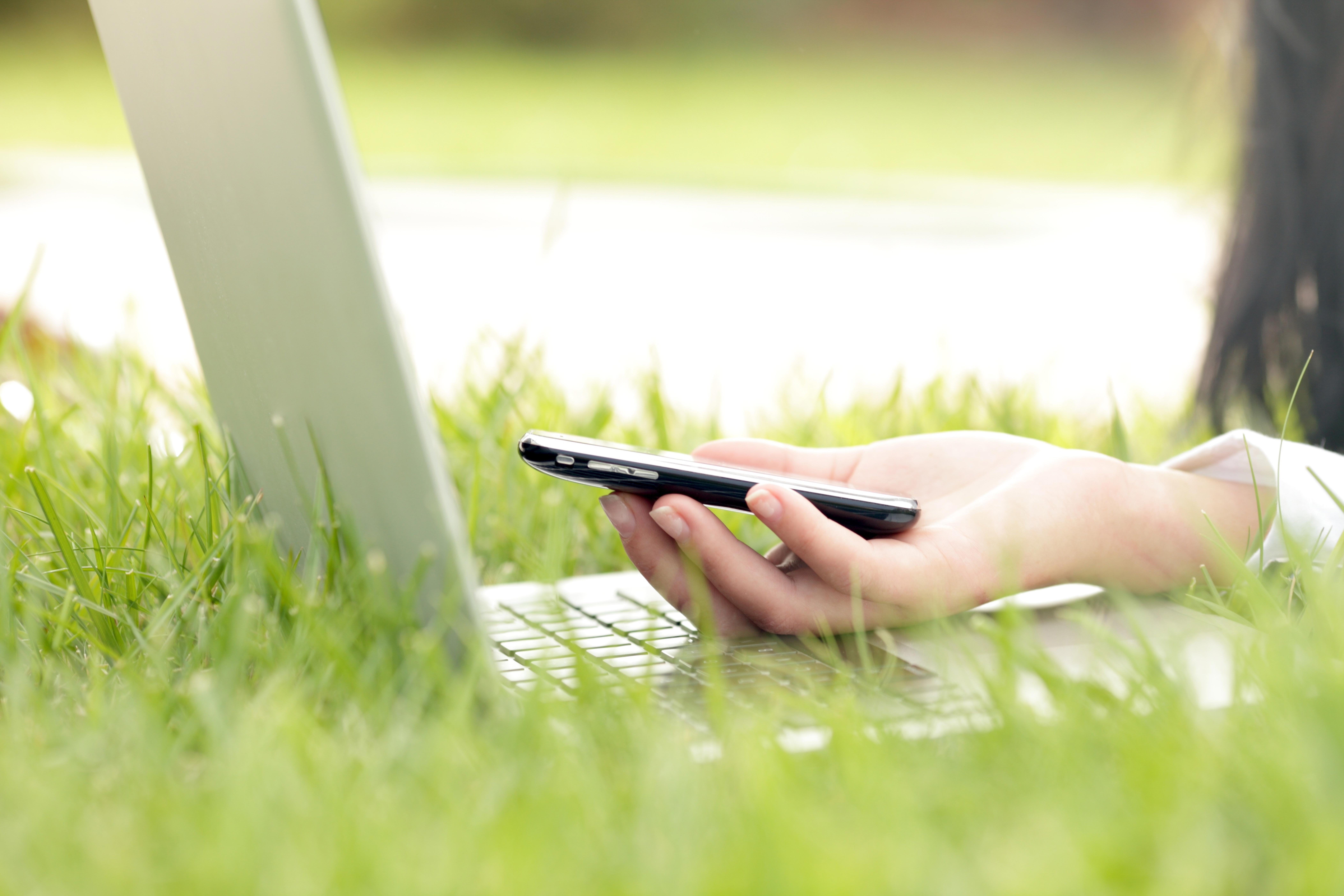 image-of-womans-hand-holding-a-phone-near-laptop_8424-x-5616-px-1