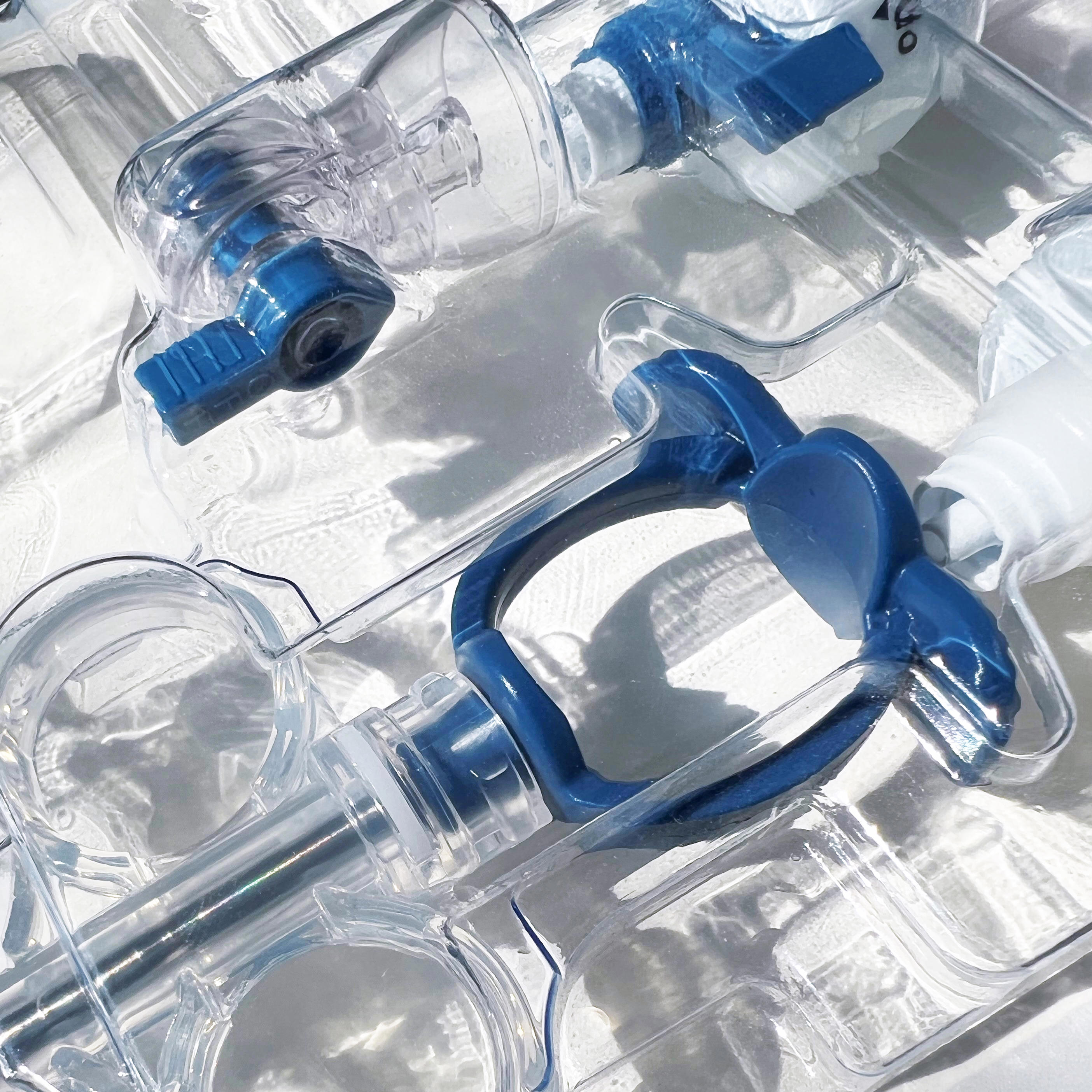 Nahaufnahme von einem Medizinprodukt mit transparenten Kunststoffteilen und blauen Ventilen. 