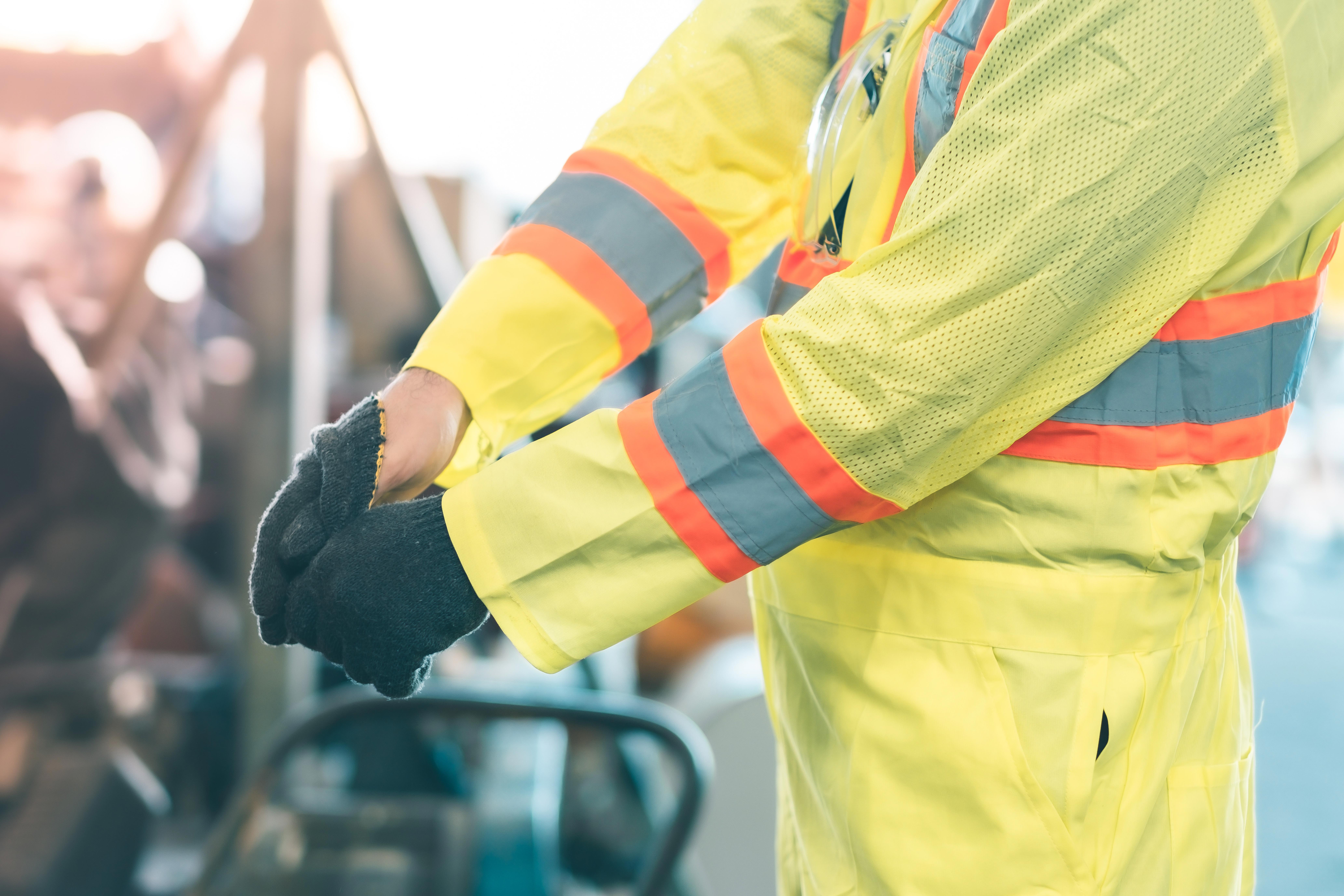 close-up-of-worker-hands-in-protective-workwear-and-gloves-industrial-background_8263-x-5509-px