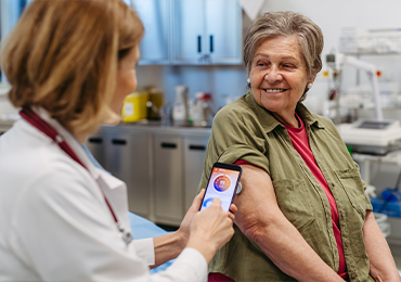 Healthcare professional using a smartphone to scan a patient’s arm in a clinical setting, illustrating the application of Software as a Medical Device (SaMD) in real-world diagnostics and patient care.