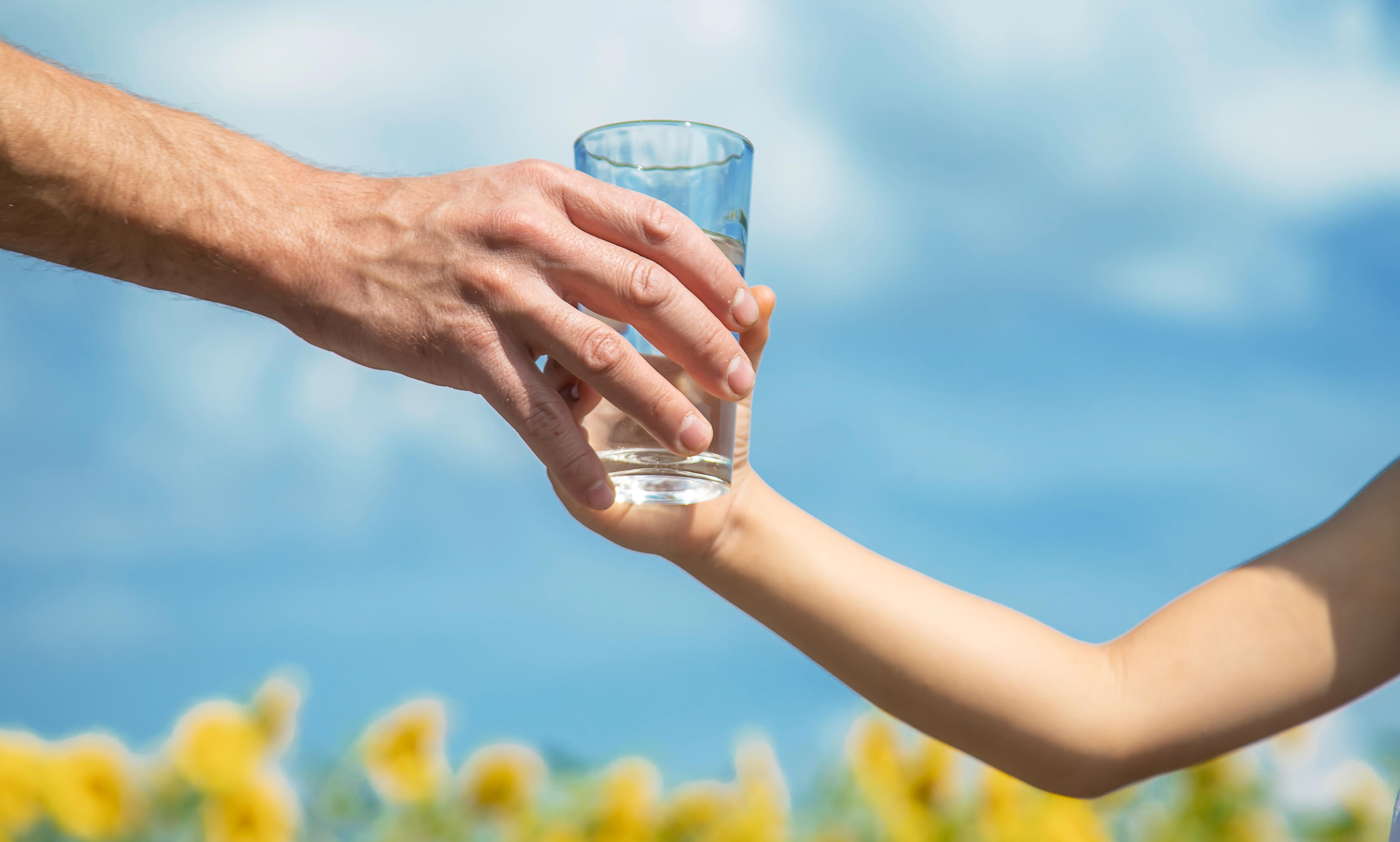 hand-giving-glass-of-water-to-child-2026-01-07-00-43-31-utc
