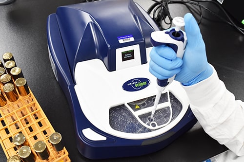 Analyse d’endotoxines bactériennes par méthode recombinant Factor C (rFC) sur système Eclipse dans un laboratoire Eurofins BioPharma Product Testing. Un technicien manipule une pipette au-dessus de l’appareil, avec des tubes à essai dorés en arrière-plan. Cette procédure fait partie du contrôle qualité microbiologique des produits injectables et biopharmaceutiques.