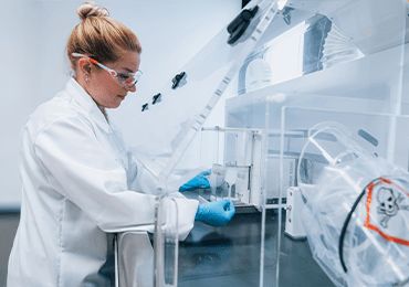 Technicien de laboratoire Eurofins BioPharma Product Testing manipulant des substances hautement actives dans une enceinte de sécurité biologique, illustrant les protocoles stricts de sécurité, de confinement et de traçabilité appliqués aux tests sur matières toxiques puissantes de catégorie 5, conformément aux normes pharmaceutiques internationales.