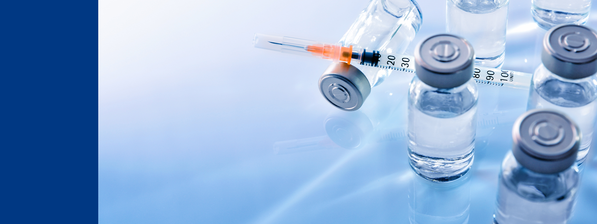 Vials de médicament et seringue sur surface stérile, illustrant les tests d’intégrité des contenants pour seringues – Eurofins Biopharma Product Testing.