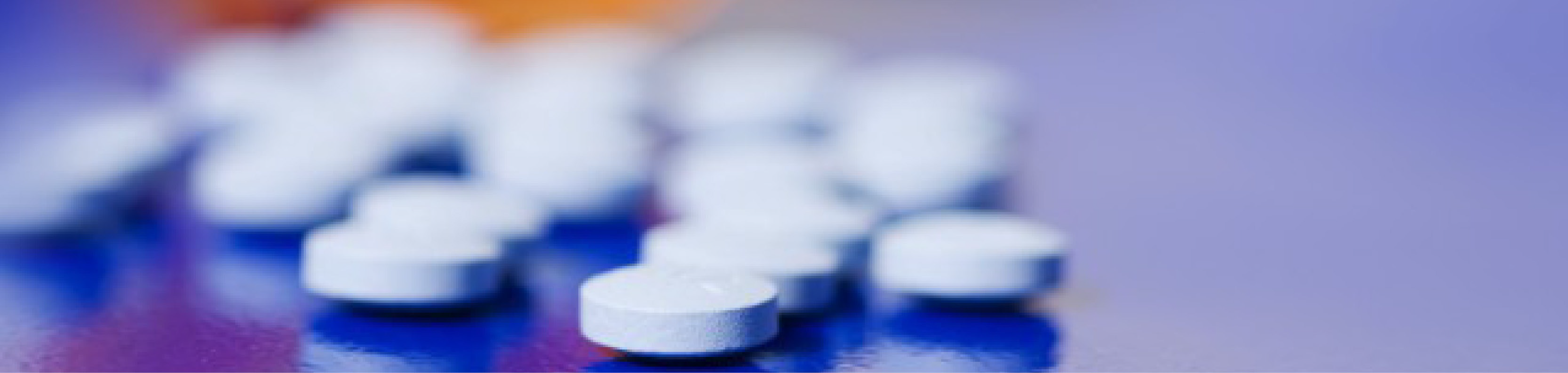 Image montrant des comprimés blancs ronds dispersés sur une surface bleue, certains nets au premier plan, d'autres flous en arrière-plan. Cette composition illustre les travaux de caractérisation des poudres réalisés chez Eurofins BioPharma Product Testing, comme l’analyse de la granulométrie, de la densité, de la compressibilité et de la cohésion des poudres utilisées dans la fabrication de formes solides orales.