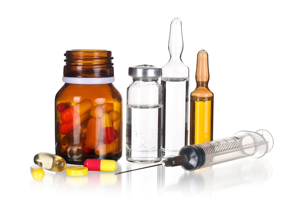 Photographie de plusieurs articles médicaux sur une surface blanche : flacons en verre contenant des capsules et des liquides, ampoules injectables, seringue et dispositifs pharmaceutiques. Cette image illustre les formes galéniques analysées par Eurofins BioPharma Product Testing dans le cadre de validations analytiques conformes aux exigences de l’ANVISA.