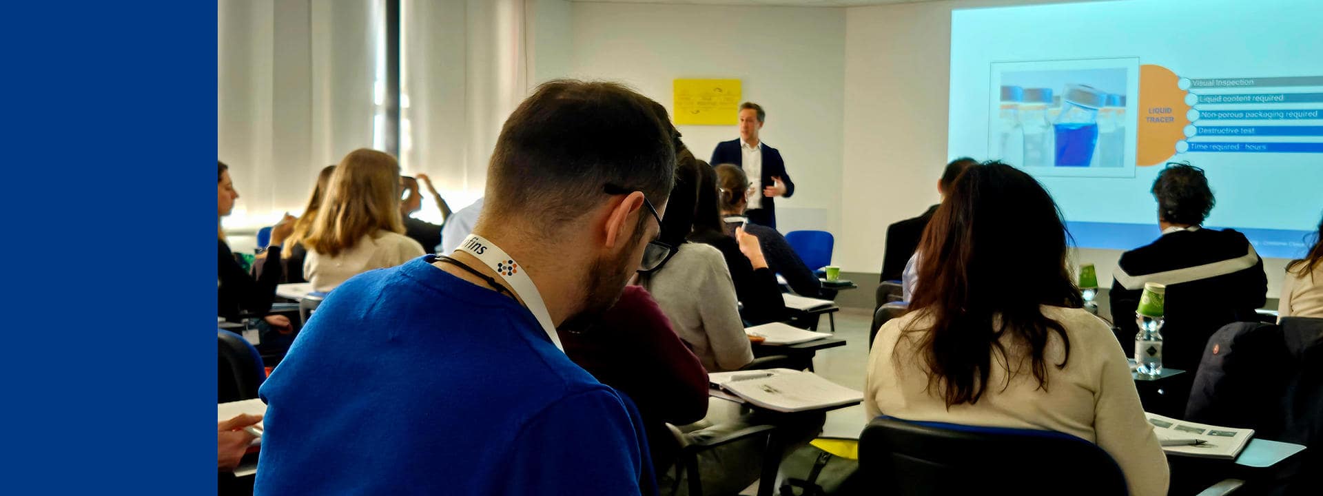 Séminaire professionnel Eurofins BioPharma Services : intervenant présentant une diapositive technique à un groupe de participants attentifs, dans une salle de formation. Les participants prennent des notes et consultent des documents imprimés, illustrant un moment d’échange et de montée en compétence sur des sujets biopharmaceutiques.