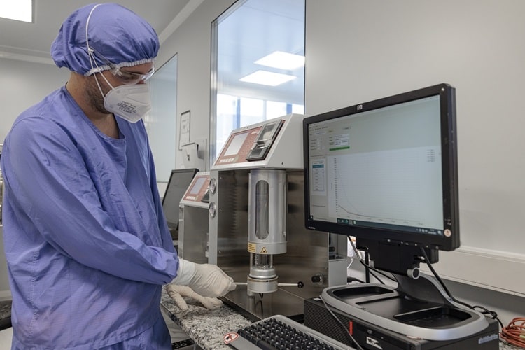 Technicien de laboratoire équipé d’une blouse, d’un masque et de lunettes de protection, manipulant un instrument d’analyse scientifique dans un environnement contrôlé. L’image illustre les protocoles rigoureux et les équipements spécialisés utilisés par Eurofins BioPharma Product Testing pour la réalisation de tests analytiques sur des échantillons biopharmaceutiques, notamment dans le cadre du contrôle qualité et de la détection de particules subvisibles.
