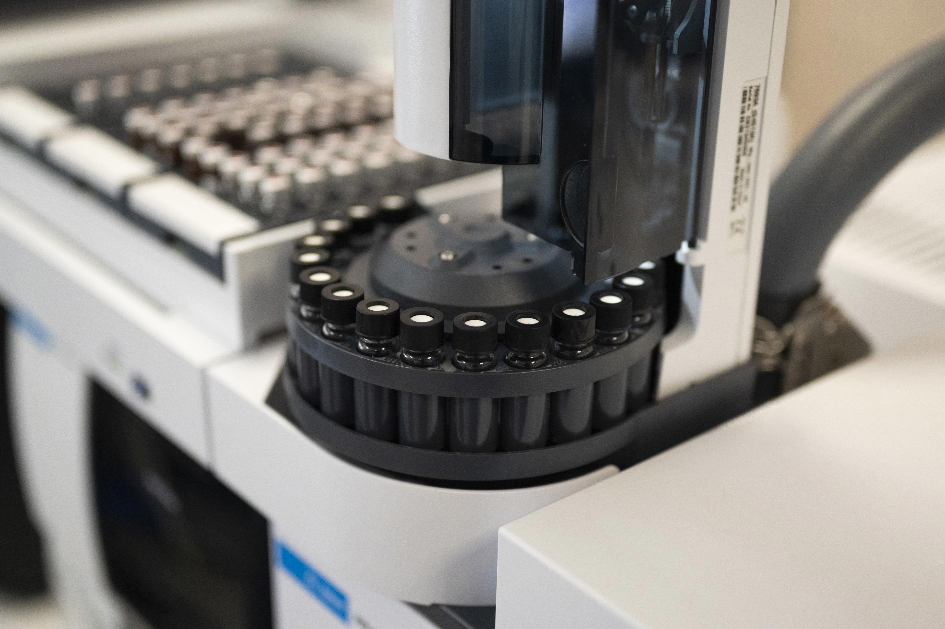 Gros plan sur un autosampler de laboratoire, équipé d’un plateau circulaire contenant plusieurs fioles d’échantillons. L’image illustre l’automatisation des analyses dans le cadre des méthodes de contrôle qualité mises en œuvre par Eurofins BioPharma Product Testing pour garantir la conformité réglementaire des produits pharmaceutiques.