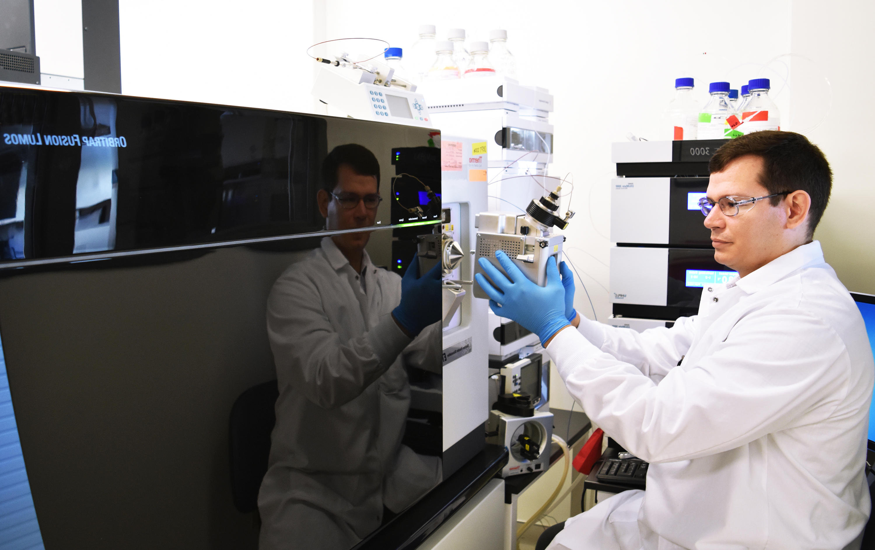 Technicien de laboratoire chez Eurofins BioPharma Product Testing manipulant un système de spectrométrie de masse pour la caractérisation de larges molécules biopharmaceutiques, dans un environnement conforme aux BPF.