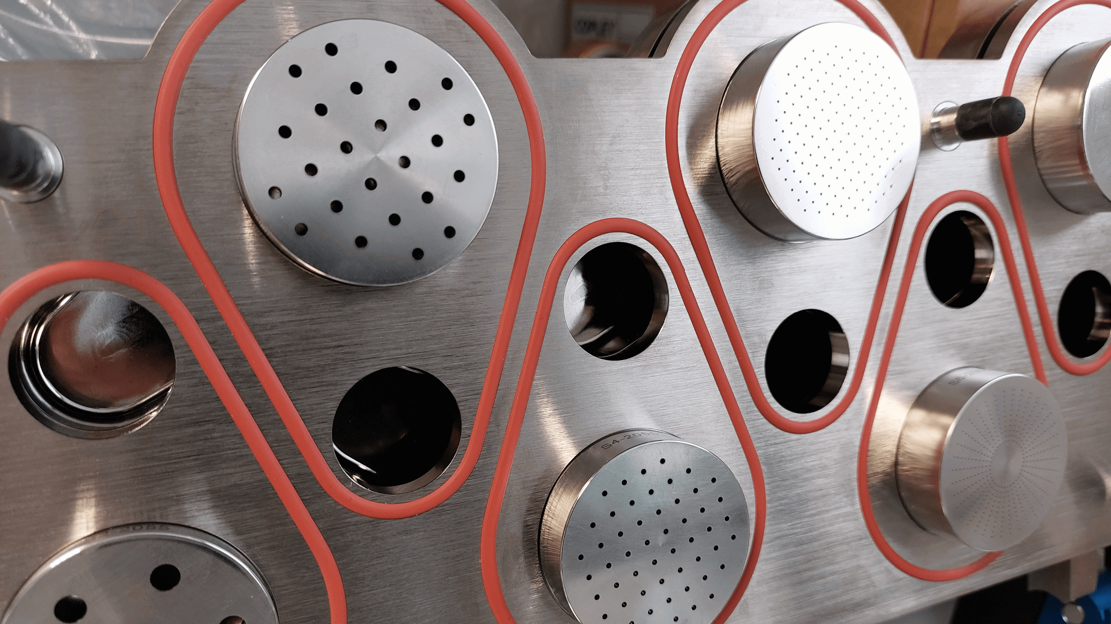 Pièce métallique utilisée dans le cadre des analyses de préparations pour inhalation et nébulisation chez Eurofins BioPharma Product Testing. La structure comporte plusieurs composants circulaires et perforés, certains encadrés en rouge, avec des ouvertures visibles sans insertion. Cette configuration suggère un dispositif de test ou de calibration pour équipements d’administration de médicaments par voie respiratoire.