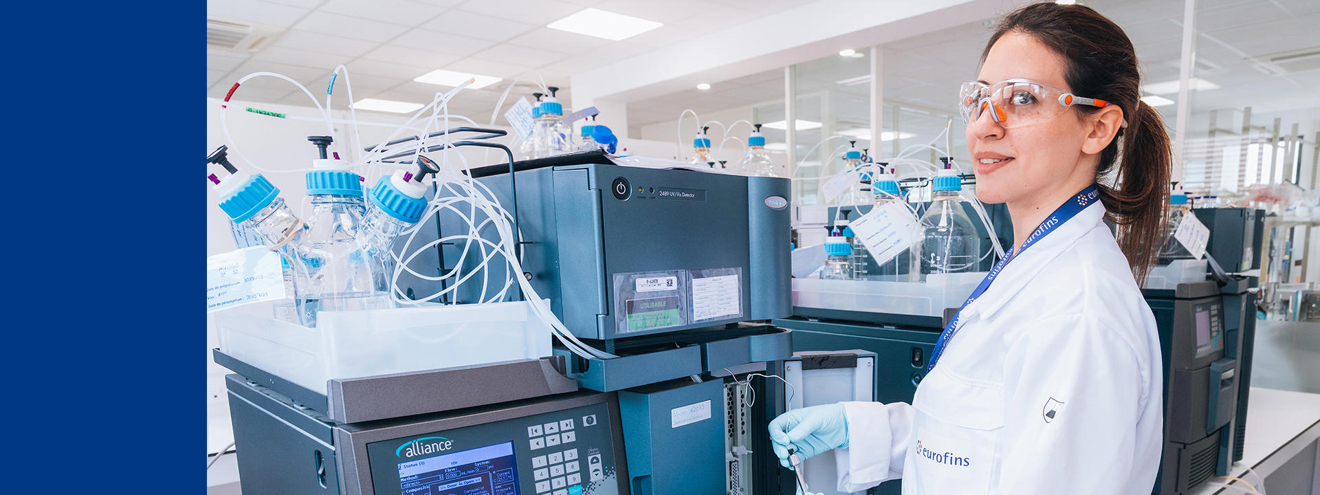 Technicienne de laboratoire Eurofins Biopharma Product Testing utilisant un système HPLC pour l’analyse de substances pharmaceutiques dans un laboratoire conforme aux normes BPF. L’image illustre l’expertise en chromatographie, le contrôle qualité, la traçabilité des données et l’environnement sécurisé dédié aux tests analytiques et à la validation des produits biopharmaceutiques.