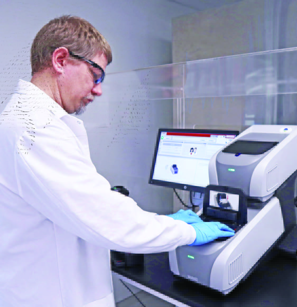 Technicien de laboratoire Eurofins Biopharma Product Testing portant une blouse blanche et des gants bleus, utilisant un système analytique connecté à un ordinateur pour une méthode microbiologique innovante. L’image montre un poste de travail équipé d’un écran affichant des données et d’un appareil automatisé sur une paillasse protégée par une paroi transparente.