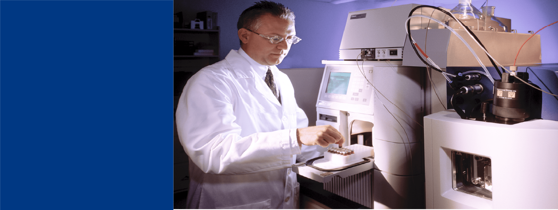 Laboratoire Eurofins BioPharma Product Testing dédié aux tests précis pour les impuretés liées aux bioprocédés. Une personne en blouse blanche manipule un échantillon sur un instrument analytique sophistiqué, équipé d’un écran et de modules de détection. L’environnement illustre un cadre conforme aux normes GMP, avec des équipements de haute précision utilisés pour garantir la qualité et la sécurité des analyses biopharmaceutiques.