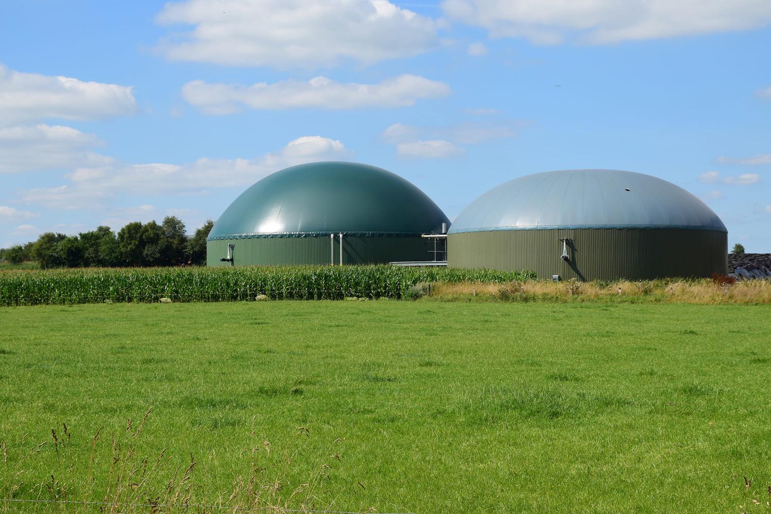 biogas-plant-for-renewable-energy-on-a-green-meadow-against-the-blue-sky-with-clouds-xl_6000x4000px