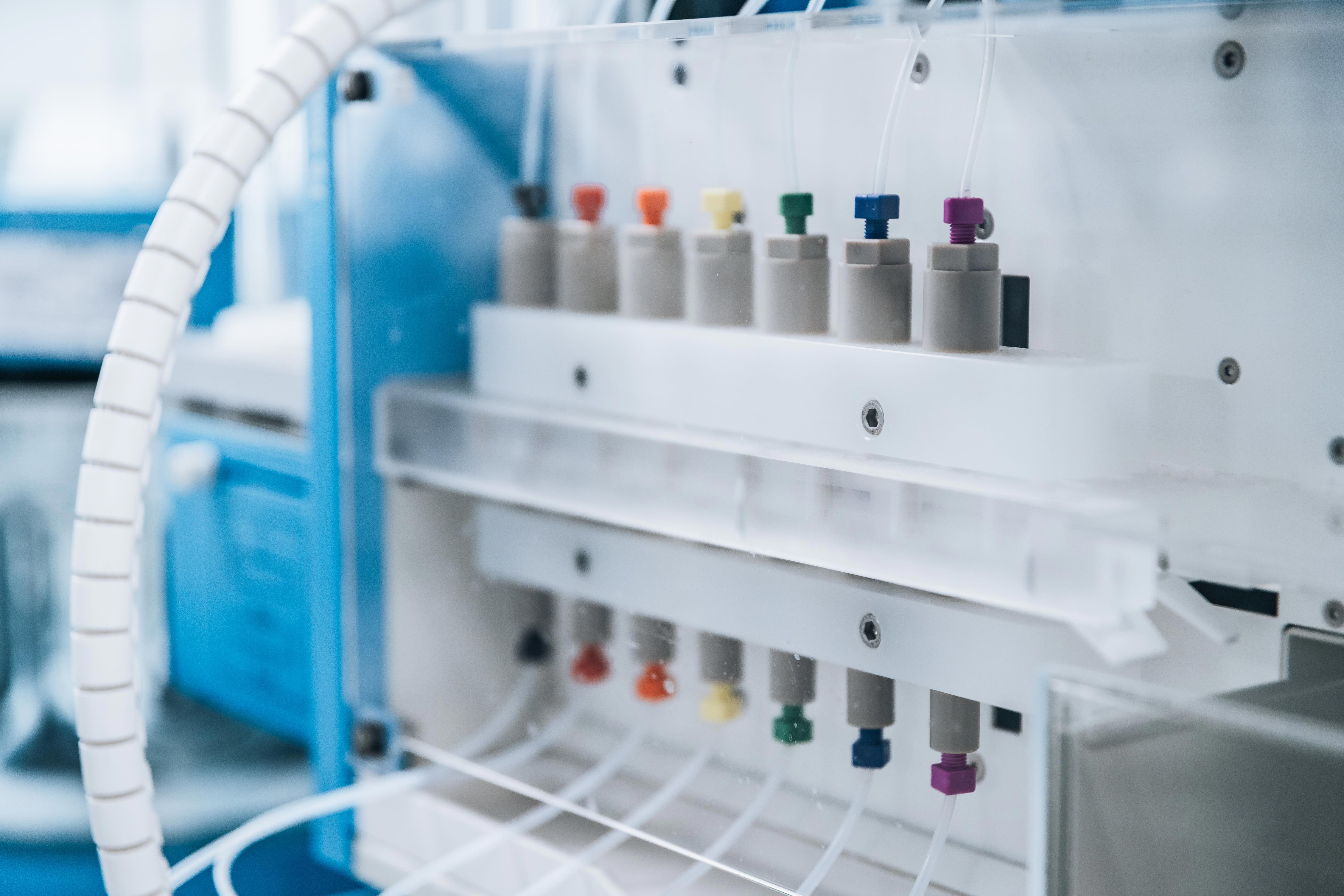 Instrument de laboratoire automatisé équipé de tubes avec bouchons colorés (rouge, orange, jaune, vert, bleu, violet), utilisé pour la manipulation ou l’analyse de liquides. L’image illustre les équipements analytiques utilisés par Eurofins BioPharma Product Testing dans le cadre des études de dissolution et de contrôle qualité pharmaceutique.