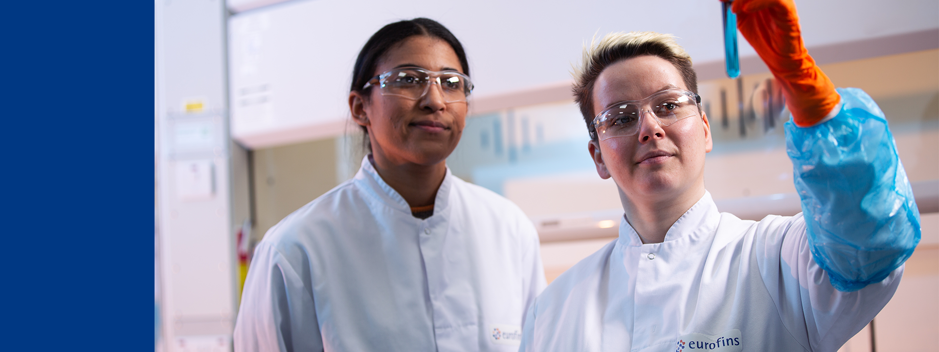 Au sein d’un laboratoire certifié ISO 17025 d’Eurofins BioPharma Product Testing, deux techniciens en blouse blanche, équipés de gants nitrile et de lunettes de protection, procèdent à l’examen visuel d’un échantillon liquide dans un tube à essai. Cette opération s’inscrit dans un processus conforme aux Bonnes Pratiques de Fabrication (BPF/GMP), dédié au contrôle qualité, à la validation analytique et à la caractérisation physico-chimique de substances actives et de produits biopharmaceutiques.