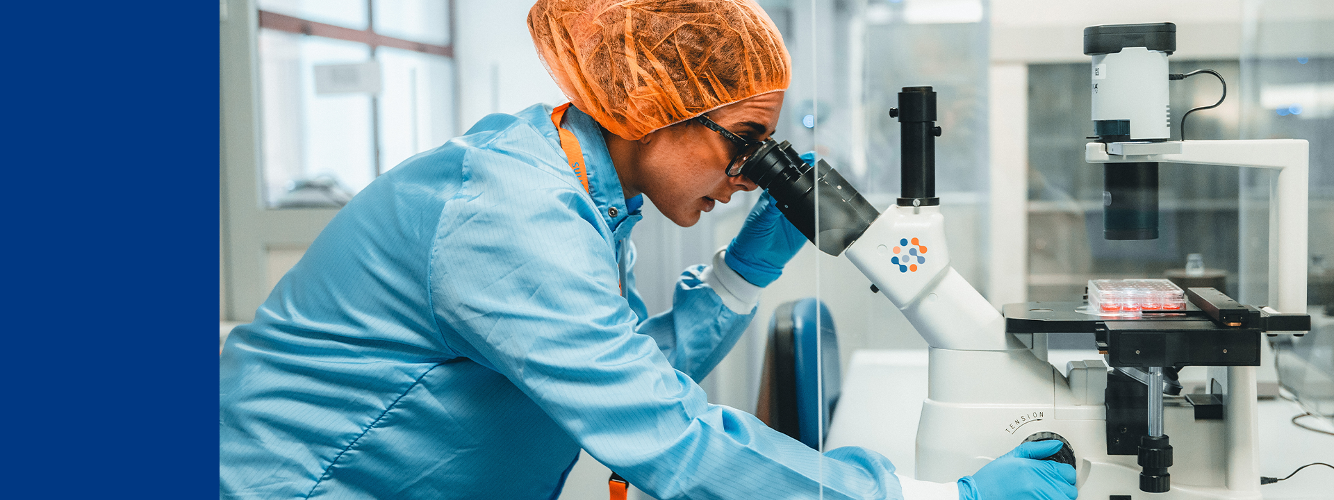 Technicienne de laboratoire chez Eurofins Biopharma Product Testing effectuant un essai de puissance des antibiotiques à l’aide d’un microscope et d’une boîte de culture, conformément aux pharmacopées USP <81> et Ph. Eur. 2.7.2, pour évaluer l’activité antimicrobienne, garantir l’efficacité thérapeutique et assurer la conformité réglementaire des médicaments injectables.