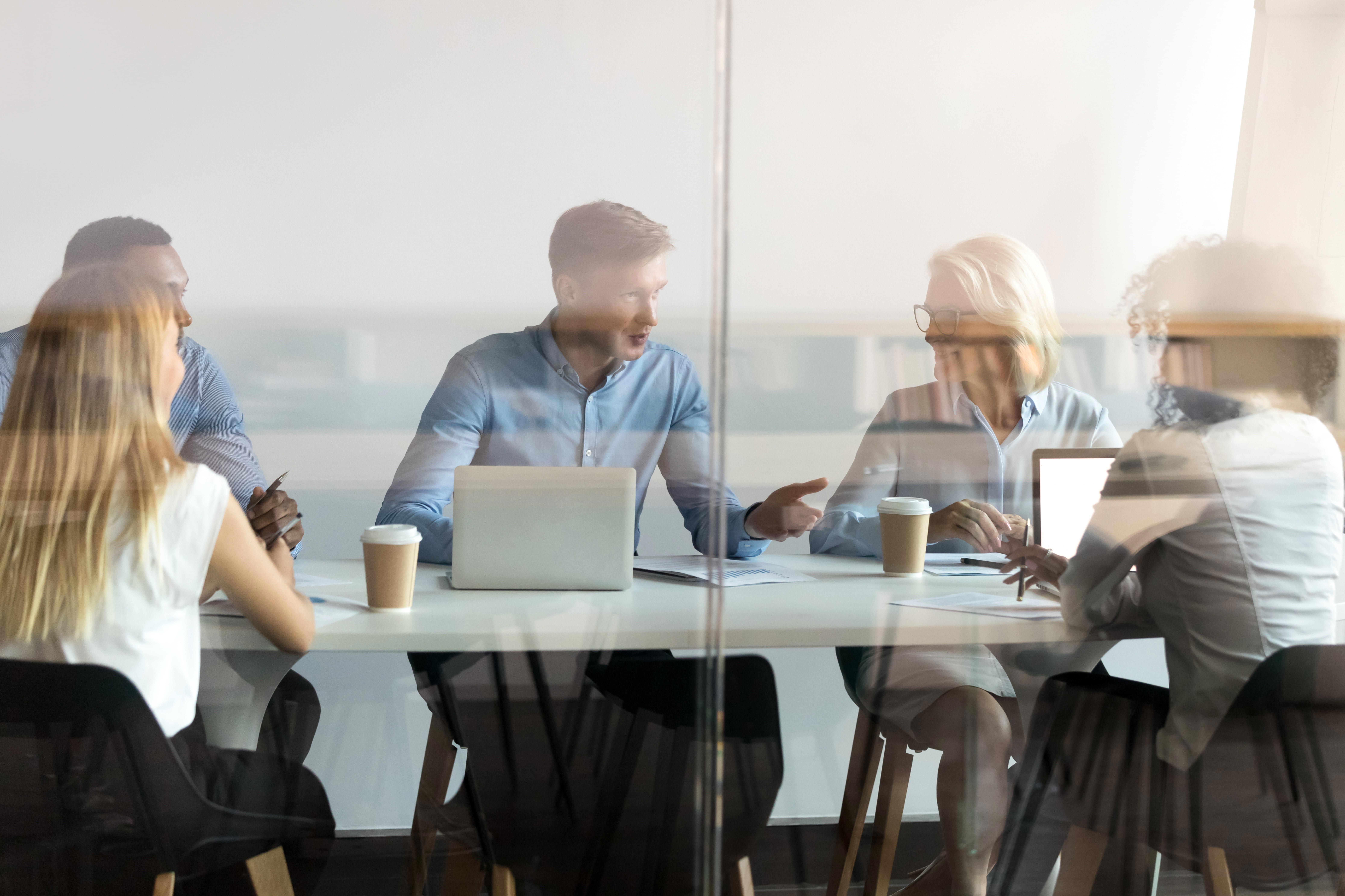 diverse-business-people-negotiate-sit-at-conference-table-behind-closed-glass-door_8929-x-5953-px-1