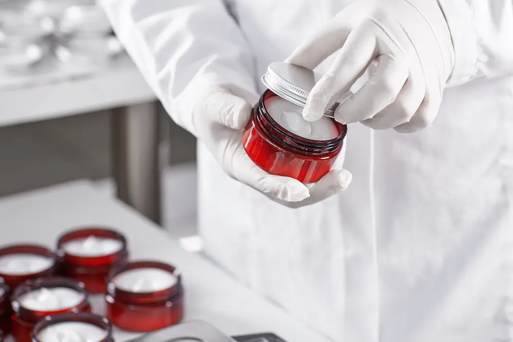 worker-filling-container-with-cream-cosmetic-factory-1