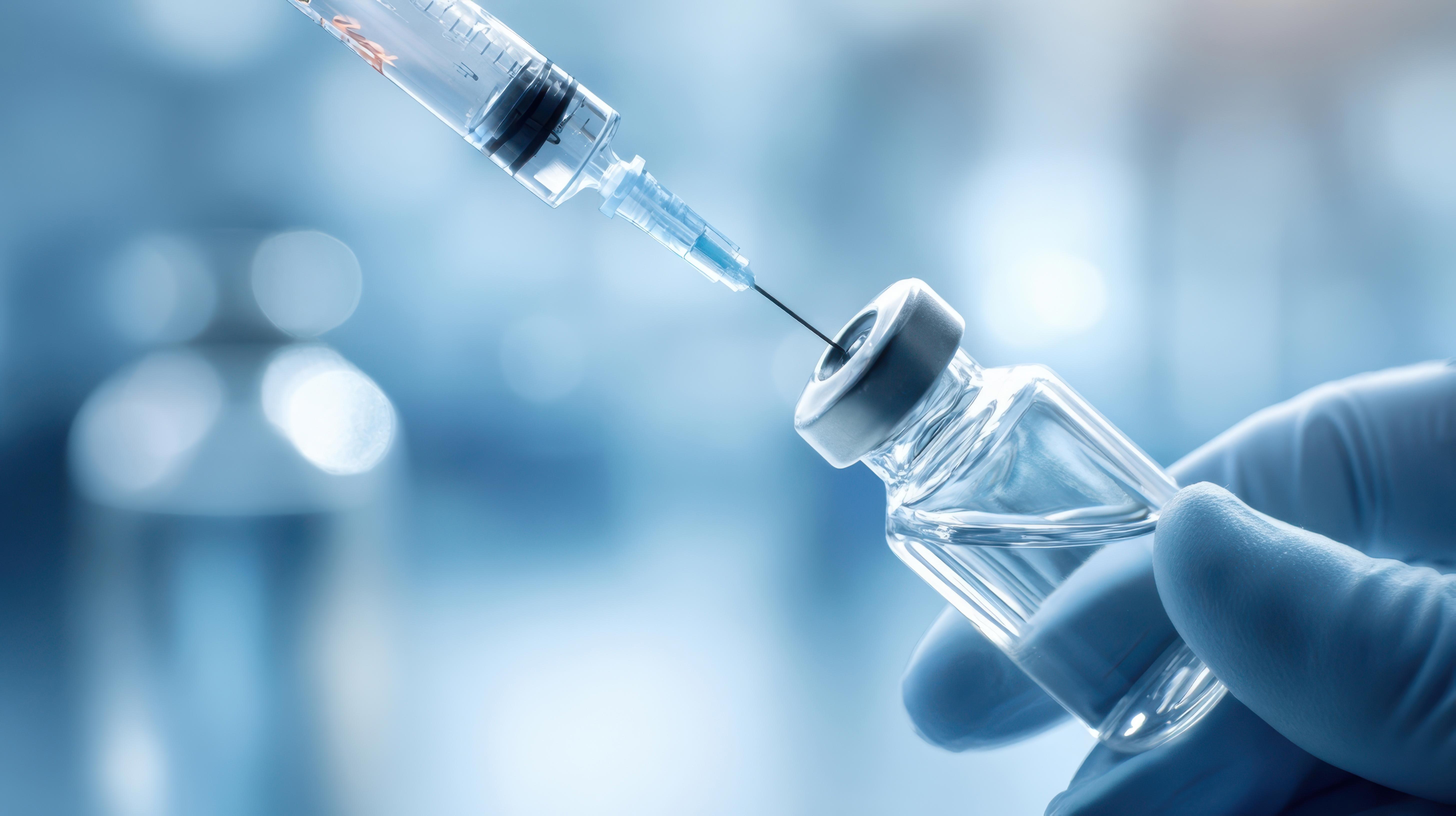 the-vaccine-vial-being-prepared-for-injection-with-a-syringe-in-a-medical-setting_adobestock_1562188577